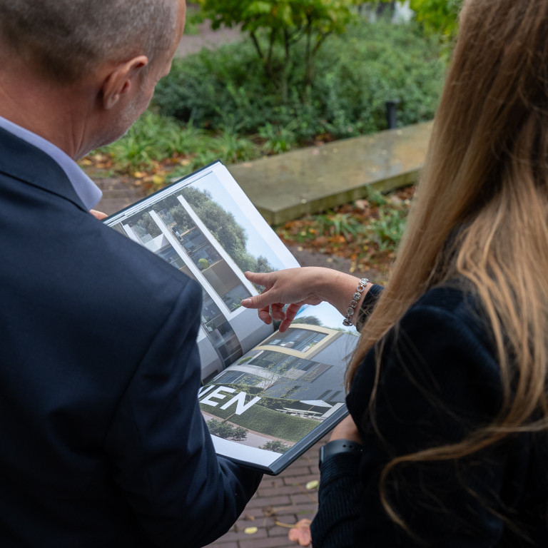 Twee personen kijken naar een projectboek
