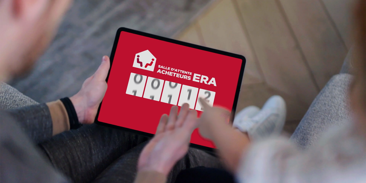 Deux personnes regardent la Salle d'Attente Acheteurs ERA sur une tablette.