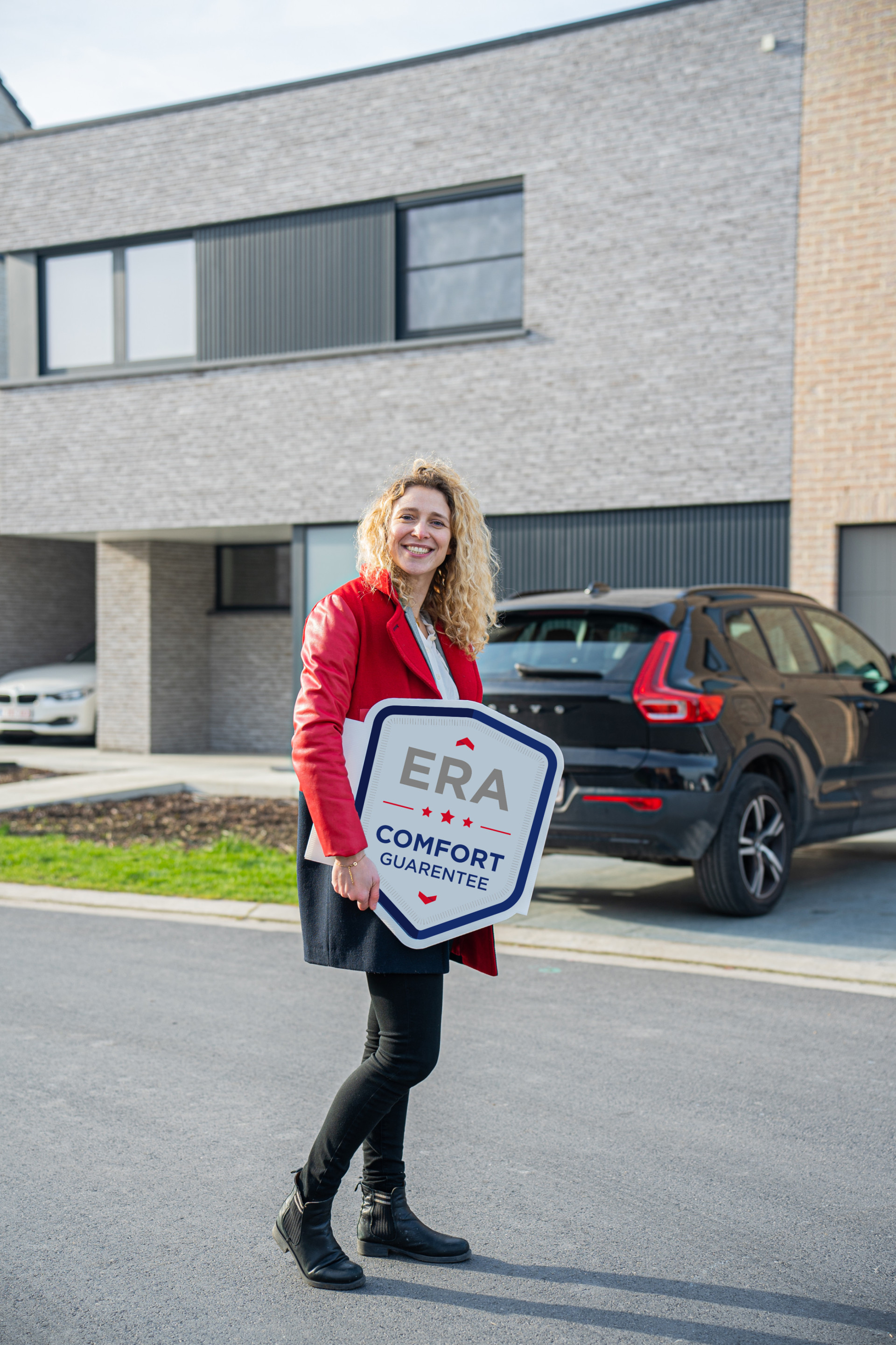 An ERA broker holds an ERA Comfort Guarantee V-Board.