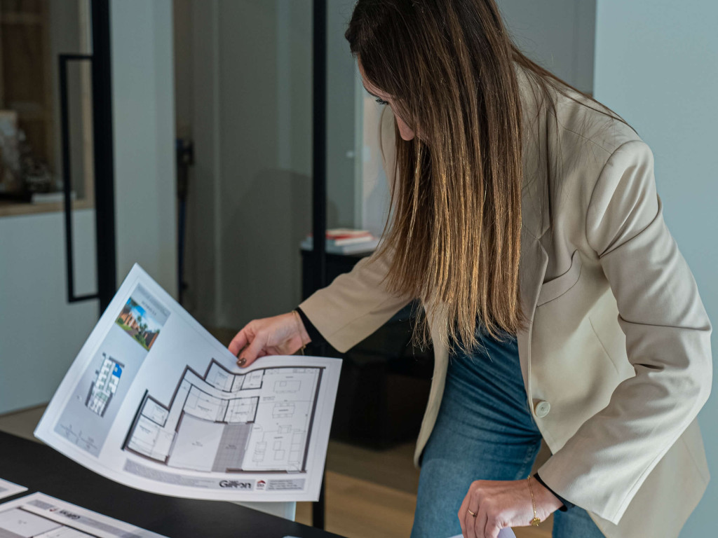 Een vrouw bekijkt bouwplannen van een woning.