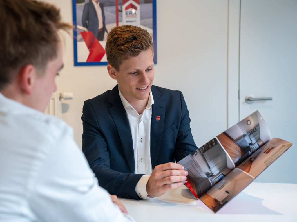 Makelaar toont de ERA Luxebrochure