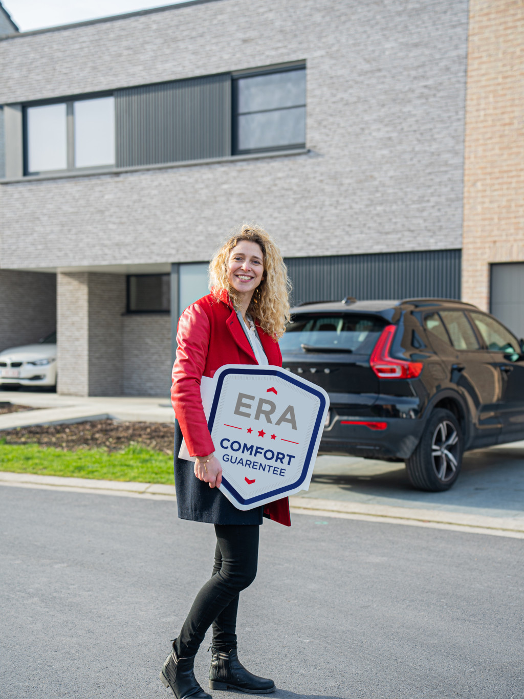 An ERA broker holds an ERA Comfort Guarantee V-Board.